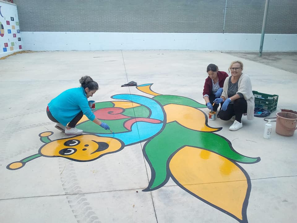 Vecinas de Pruna pintan dibujos en el suelo de un colegio para que juegue el alumnado